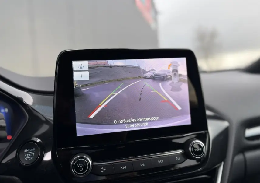Écran tactile intérieur montrant la caméra de recul 180° du Ford Puma gris Solar, avec bouton démarrage et commandes audio.