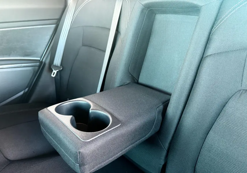 Accoudoir central arrière déployé avec porte-gobelets dans l'habitacle noir du Kia Sportage blanc 2015.