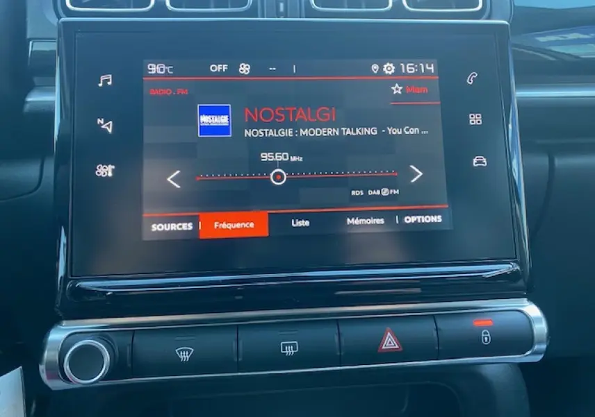 Écran tactile central de la Citroën C3 2023 affichant la radio Nostalgie, avec commandes climatisation et alertes en dessous.