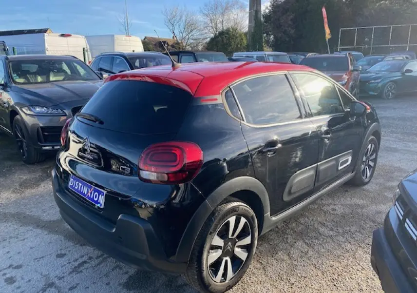 Citroën C3 2023 noir avec toit rouge, vue 3/4 arrière droit, vitres surteintées et protections latérales grises.