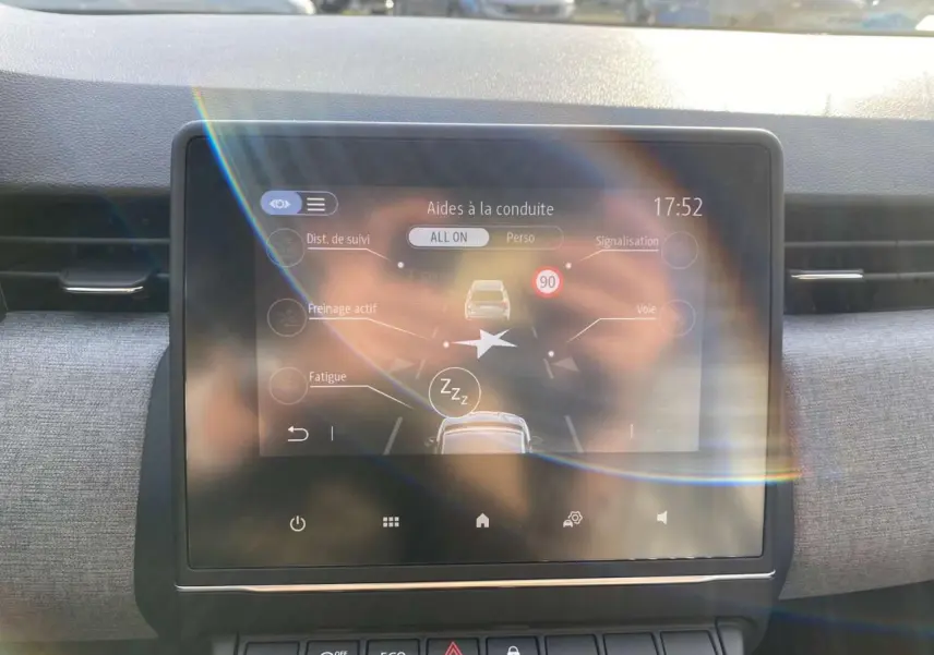 Écran tactile central de la Renault Clio 1.5 Blue dCi 2025 montrant les aides à la conduite, intérieur gris clair.