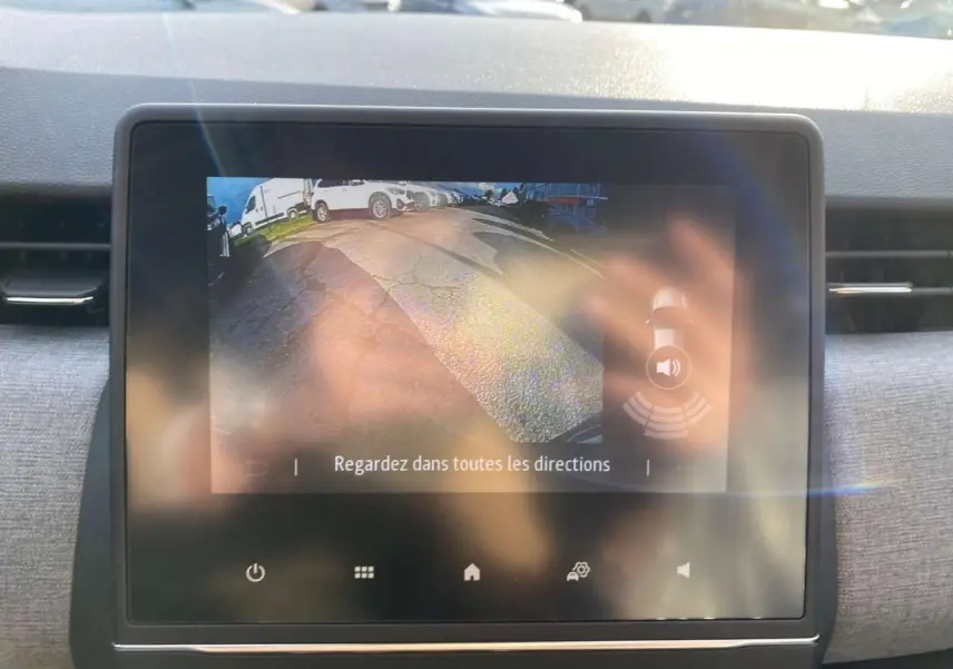 Écran tactile du système multimédia Renault Clio 2025 affichant la caméra de recul avec vue arrière et alertes de proximité.