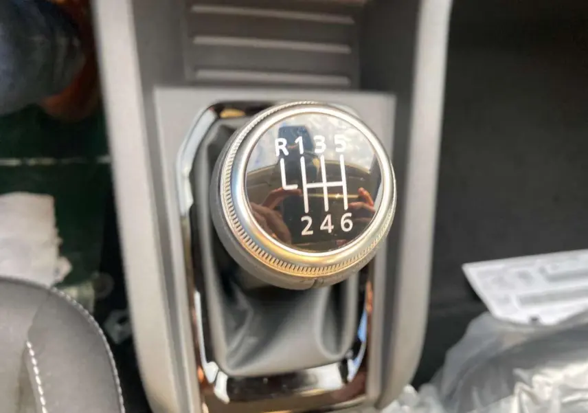 Gros plan sur le levier de vitesses manuel de la Renault Clio 1.5 Blue dCi noir, montrant les six rapports et la marche arrière.