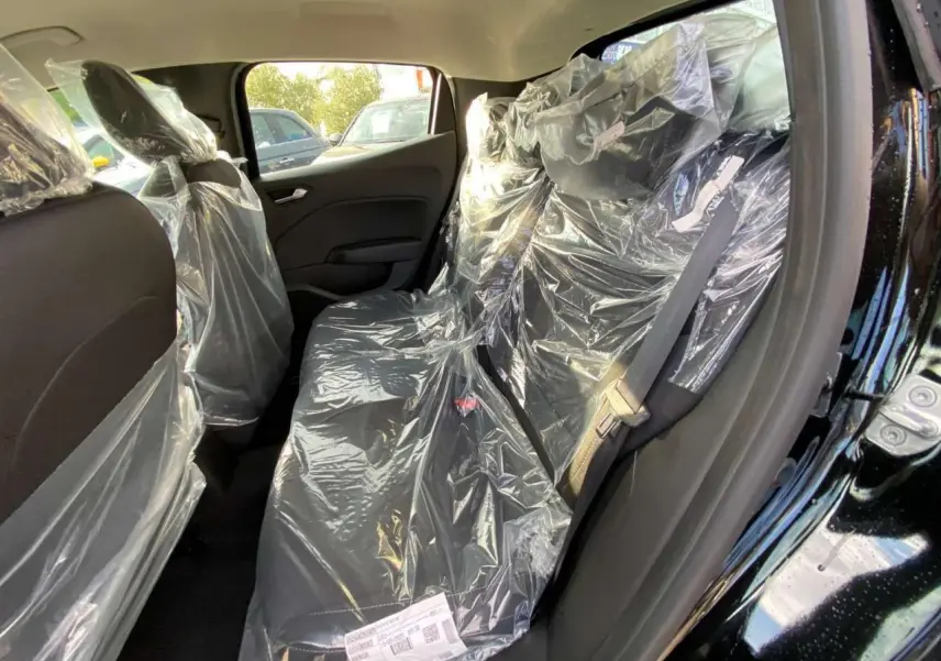 Vue intérieure côté droit des sièges arrière noirs protégés par des housses plastiques dans une Renault Clio 2025.