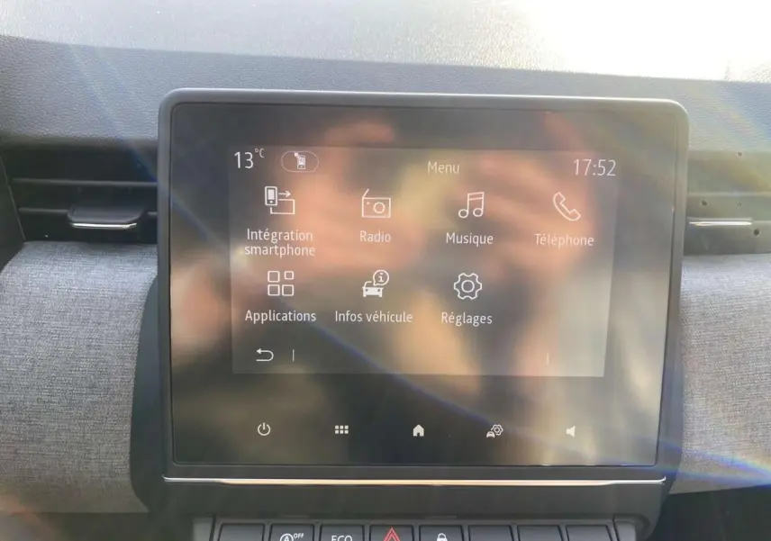 Écran tactile central de la Renault Clio 1.5 Blue dCi 2025 affichant le menu principal, intérieur gris.