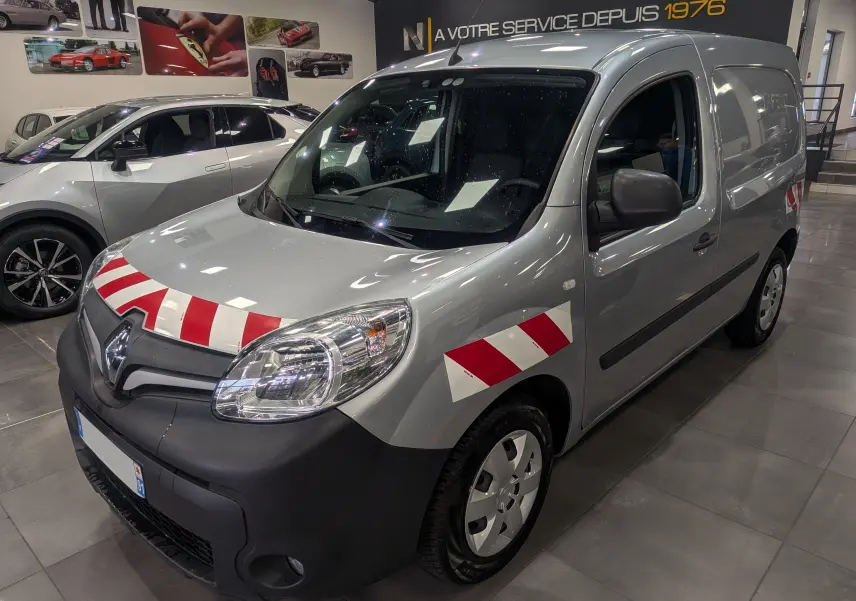 Renault Kangoo Express gris Highland en 3/4 avant droit, avec bandes rouges et blanches de sécurité sur capot et aile.