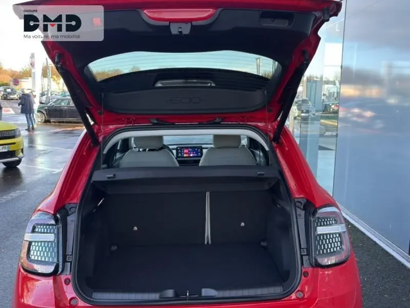 Coffre ouvert vu de l'arrière d'une FIAT 600 rouge 2026 avec feux arrière LED et intérieur clair visible.