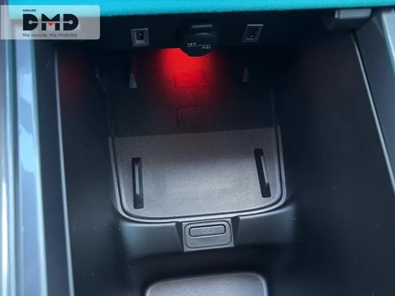 Gros plan sur le compartiment de rangement central avec éclairage rouge intérieur du Fiat 600 rouge 2026.