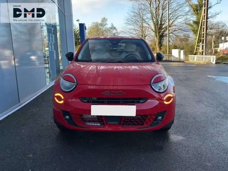 Vue avant d'une FIAT 600 rouge avec feux diurnes LED allumés sur un parking extérieur.