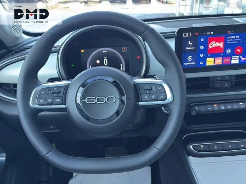 Vue intérieure centrée sur le volant noir marqué 600 et l'écran tactile du tableau de bord de la Fiat 600.