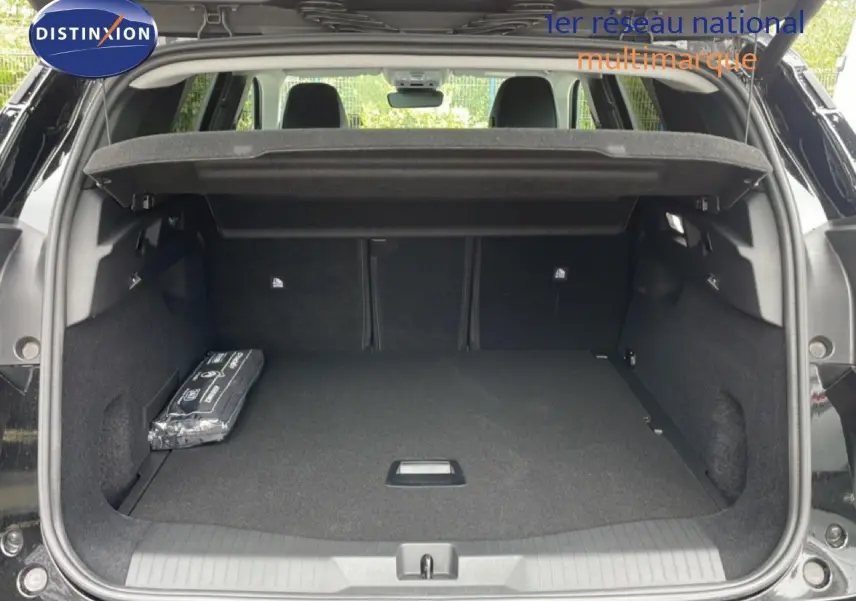 Coffre ouvert vu de l'arrière d'un Citroën C5 Aircross noir perle métal, avec cache-bagages et intérieur spacieux.