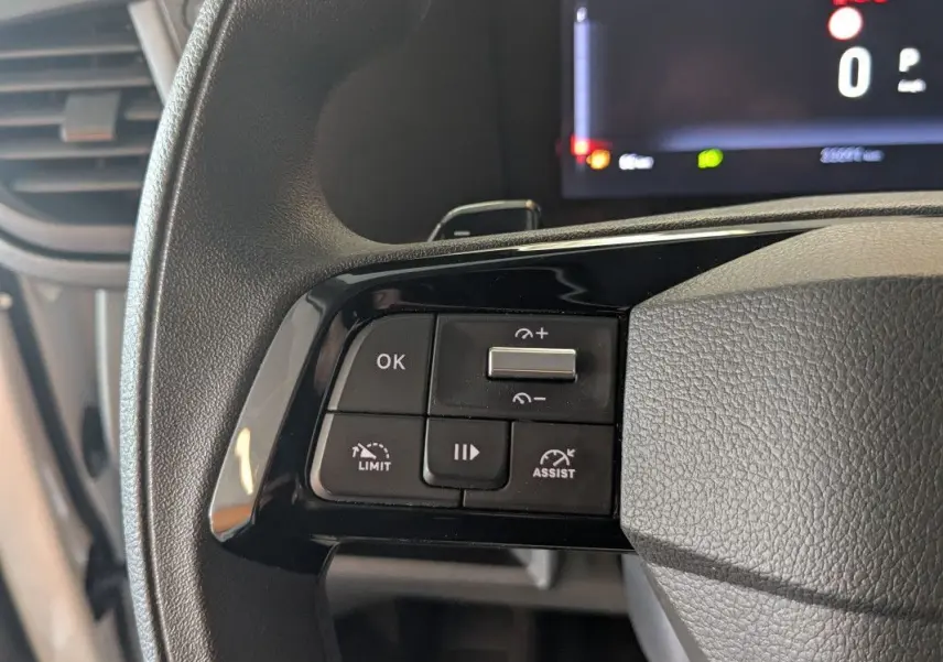 Gros plan sur les commandes au volant du FIAT Scudo Fourgon blanc, avec écran digital en arrière-plan.