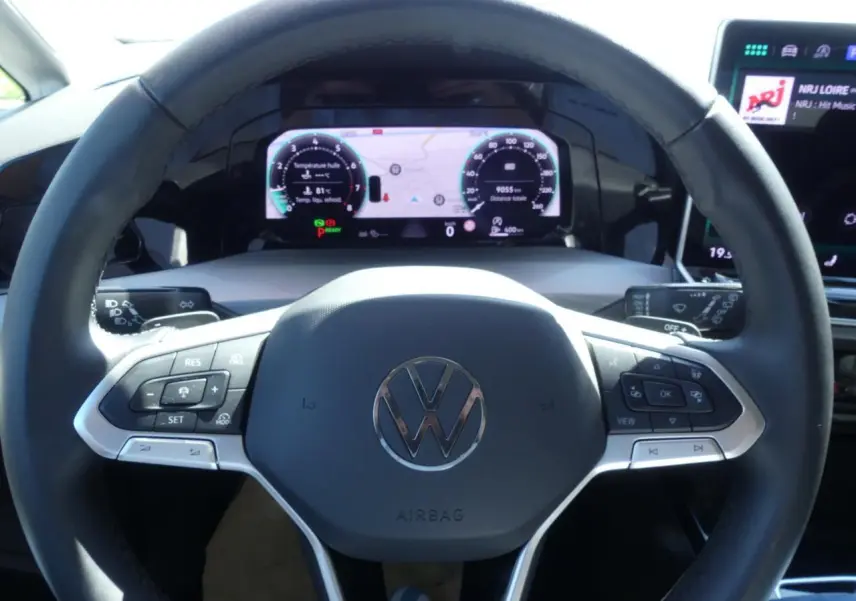 Volant multifonctions cuir noir de Volkswagen Golf 1.5 eTSI 2024 avec tableau de bord digital et écran tactile visible.