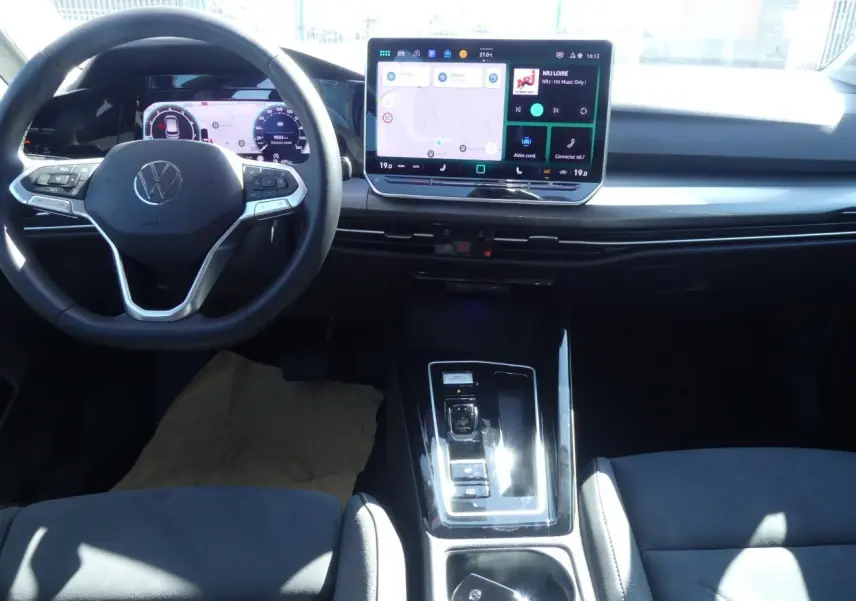 Vue intérieure avant de la Volkswagen Golf Style 2024, tableau de bord digital et écran tactile central lumineux