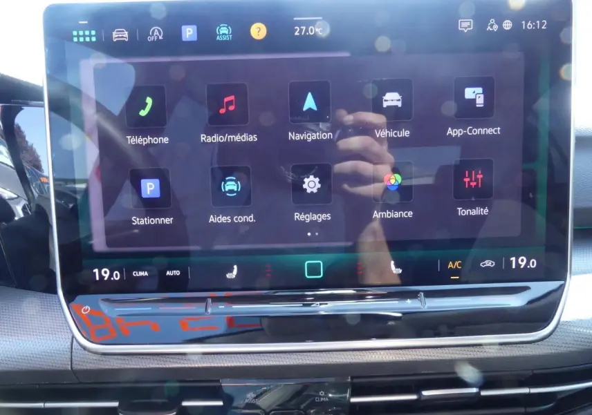 Écran tactile central de la Volkswagen Golf 1.5 eTSI 2024 affichant les menus de navigation et réglages, intérieur noir.