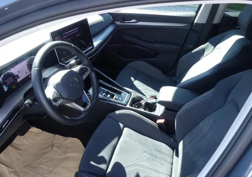 Intérieur avant côté conducteur de Volkswagen Golf 2024 avec sièges microfleece gris et tableau de bord digital.