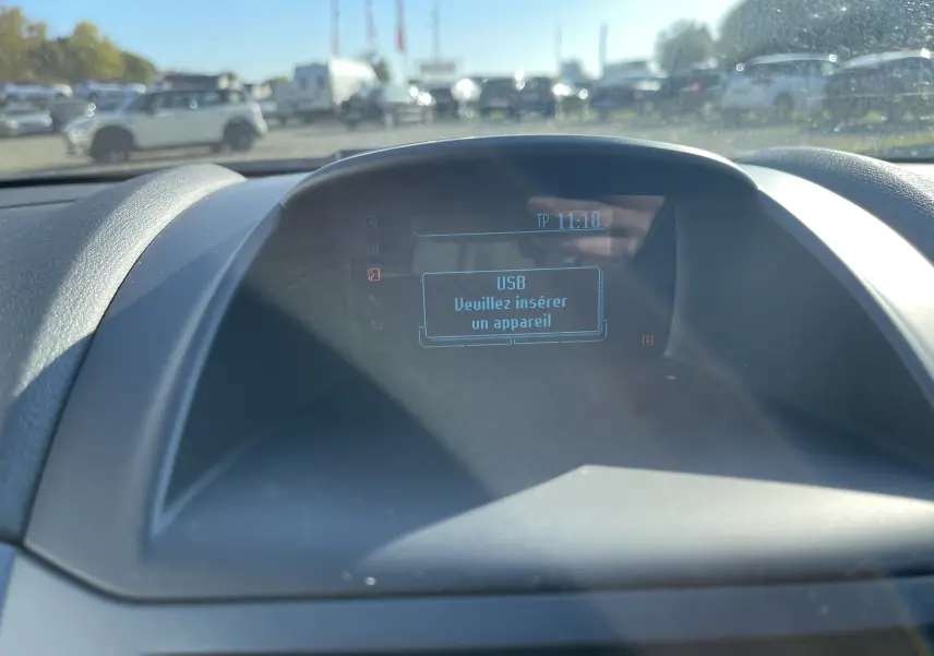 Affichage central du tableau de bord de la Ford Fiesta 2014, écran indiquant "USB veuillez insérer un appareil" en intérieur.