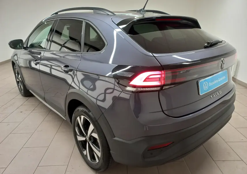 Vue 3/4 arrière droite du Volkswagen Taigo gris cendré avec feux LED allumés et jantes alliage Aberdeen 17 pouces.