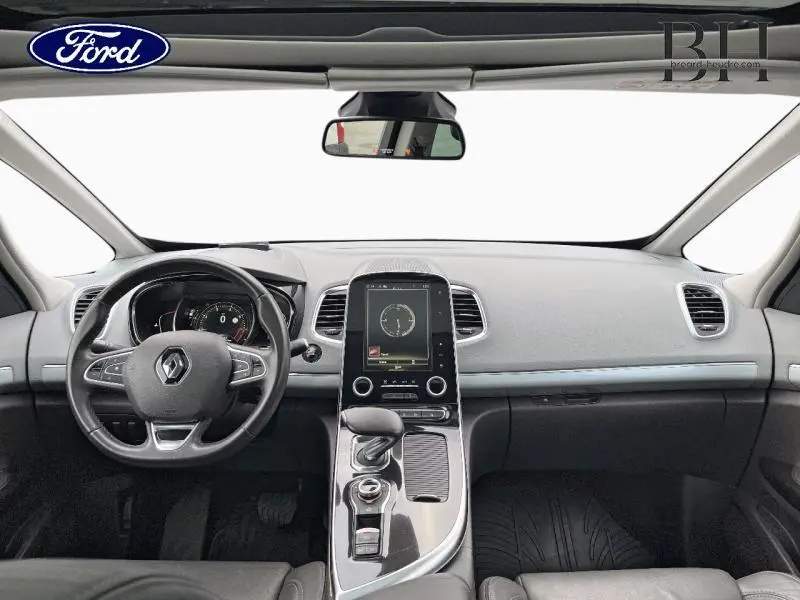 Vue intérieure avant du Renault Espace 2017 avec planche de bord gris clair et volant cuir multifonction.