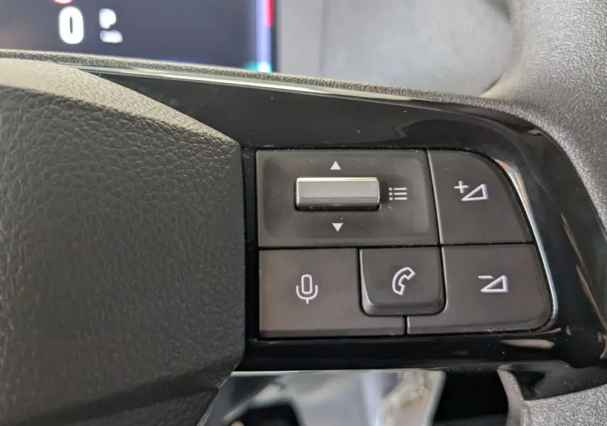 Gros plan sur les commandes noires du volant du Fiat Scudo Fourgon blanc, version 2025, avec boutons de volume et appel.