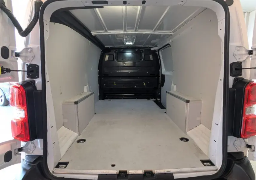 Vue arrière intérieure du fourgon FIAT Scudo XL blanc 2025, montrant l'espace de chargement vide et les portes ouvertes à 180 degrés.