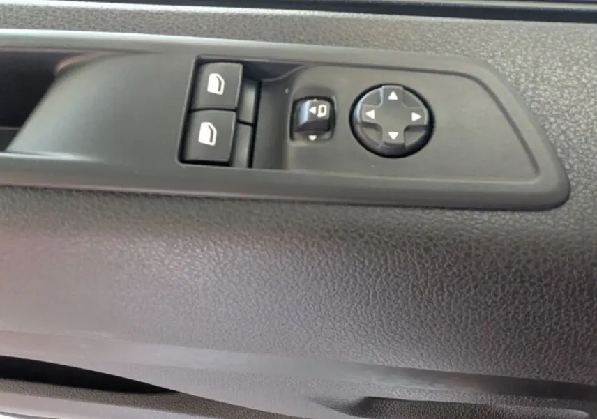 Détail des commandes de réglage des vitres et des rétroviseurs sur la porte intérieure côté conducteur du Fiat Scudo Fourgon blanc.