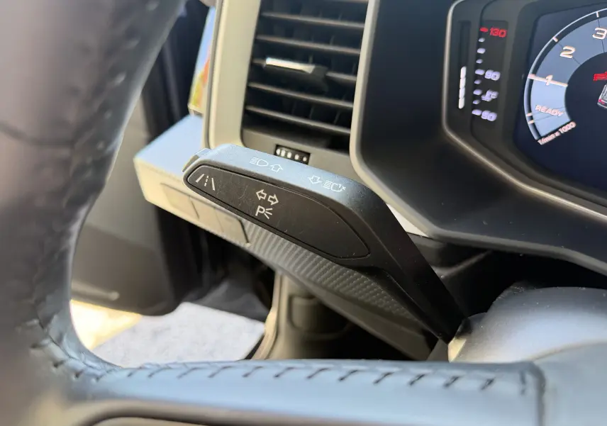 Détail du commodo de clignotant noir à gauche du volant dans l'habitacle d'une Audi A1 Sportback 2020.