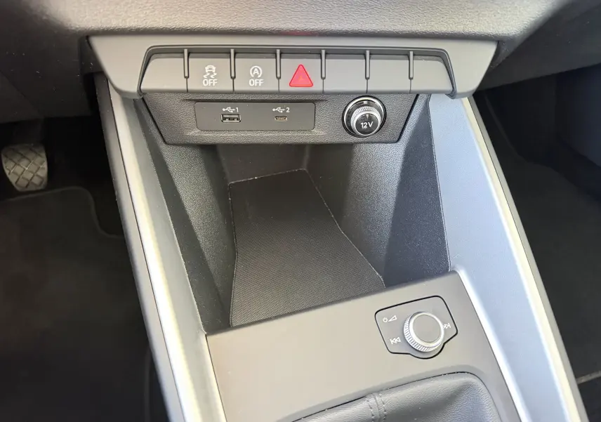 Gros plan sur la console centrale de l’Audi A1 Sportback 2020, montrant les ports USB, bouton 12V et commandes de sécurité.