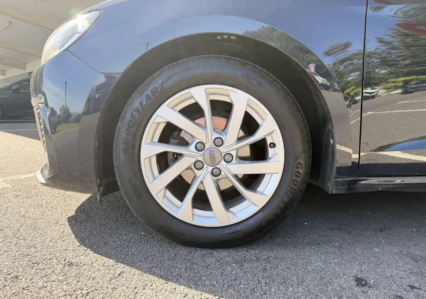 Gros plan sur la roue avant gauche d’une Audi A1 Sportback bleu firmament, avec jante alliage argentée et pneu Goodyear.