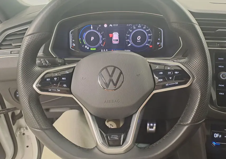Vue rapprochée du volant multifonction noir avec logo Volkswagen et tableau de bord numérique du Tiguan 1.4 eHybrid R-Line 2023.
