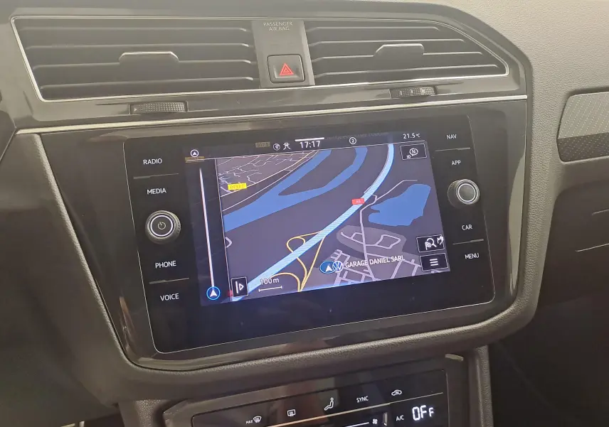 Écran tactile central du Volkswagen Tiguan 1.4 eHybrid 2023 affichant la navigation, entouré de commandes noires modernes.