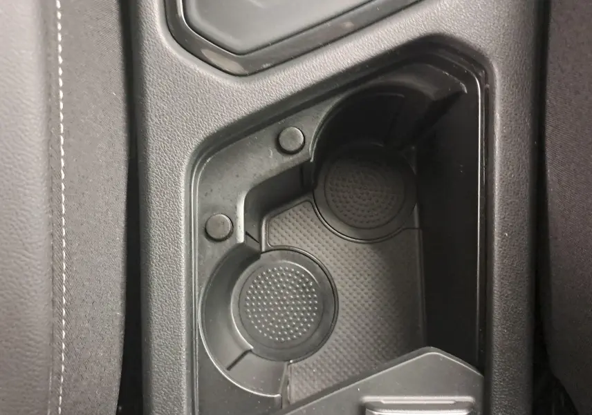Gros plan sur les porte-gobelets noirs au centre de la console du Volkswagen Tiguan 1.4 eHybrid R-Line blanc pur 2023.