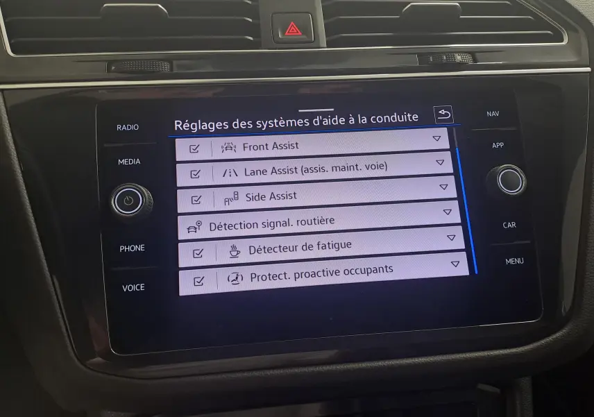 Écran tactile central du Volkswagen Tiguan 1.4 eHybrid 2023 affichant les réglages des aides à la conduite.