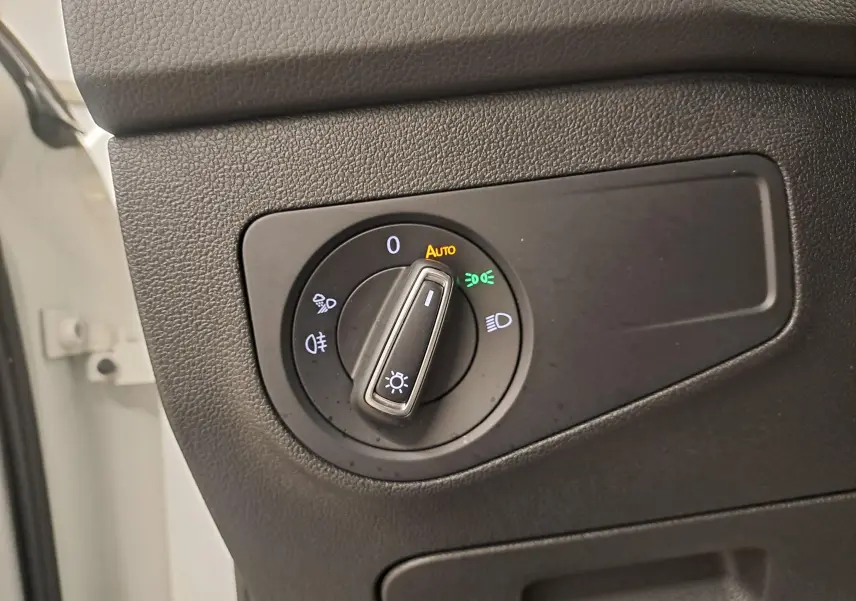 Gros plan sur le bouton de commande des phares dans l’habitacle du Volkswagen Tiguan blanc pur 2023 R-Line hybride rechargeable.