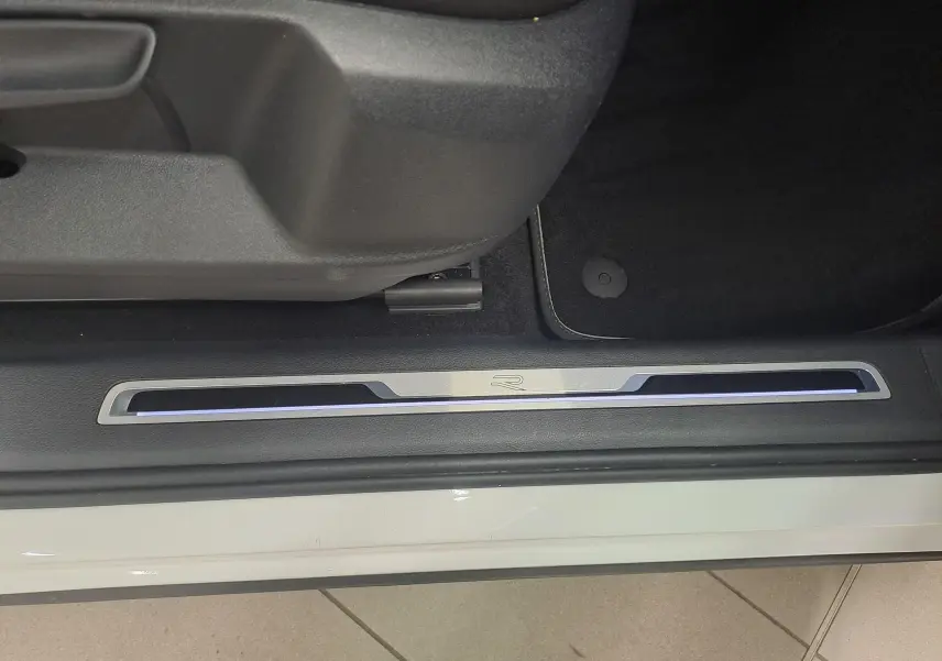 Seuil de porte côté conducteur du Volkswagen Tiguan blanc pur 2023, version R-Line avec éclairage bleu subtil.