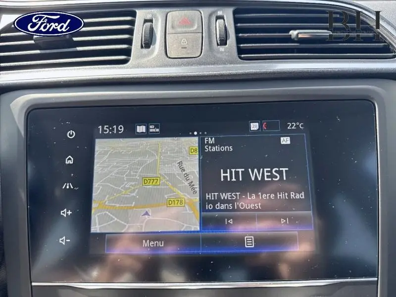 Écran tactile du système multimédia Ford affichant une carte GPS et la radio HIT WEST à 15h19, intérieur noir.