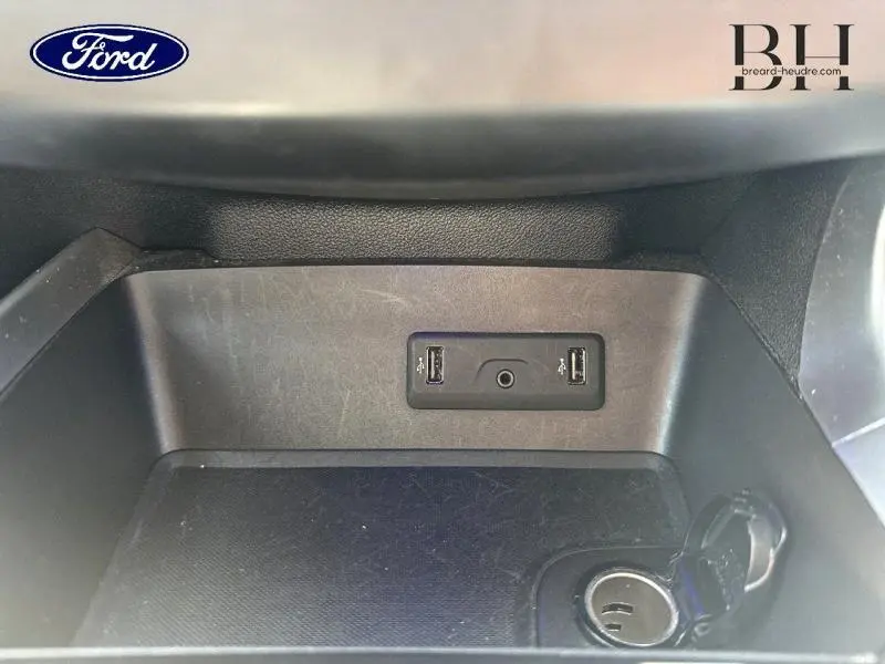 Gros plan sur la console centrale noire étoilé du Renault Kadjar 2019 avec deux ports USB et prise 12V ouverte.