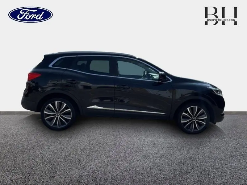 Profil côté droit d'un Renault Kadjar noir étoilé 2019 avec jantes alu et toit en verre fixe visible