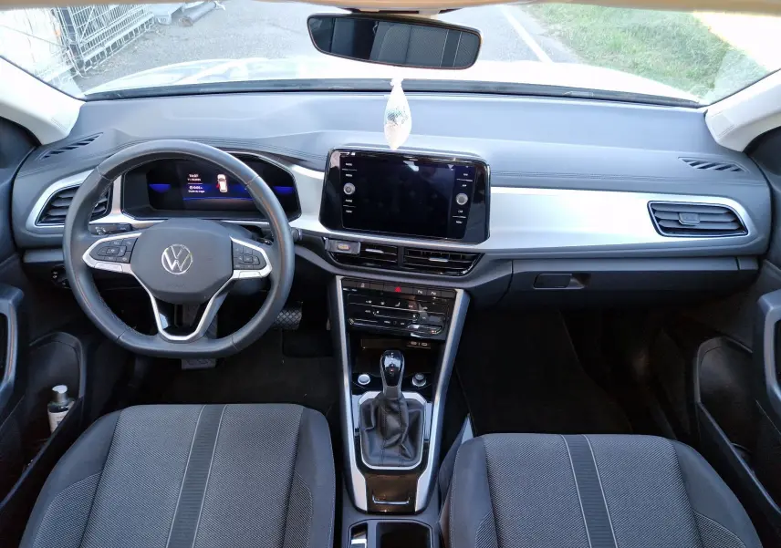 Vue intérieure du tableau de bord du Volkswagen T-Roc 2023, avec volant multifonction et écran tactile central.