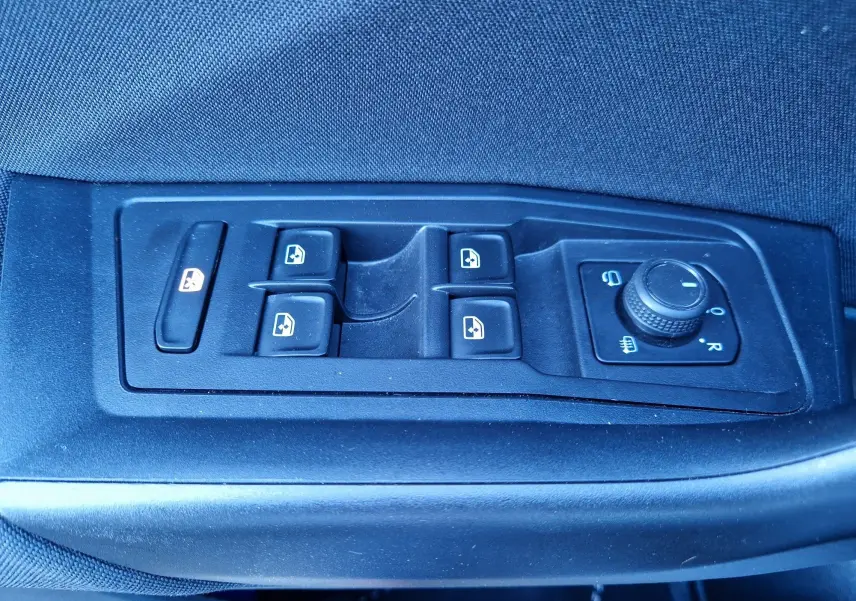 Panneau de commandes des vitres et rétroviseurs côté conducteur du Volkswagen T-Roc gris Pyrite 2023.