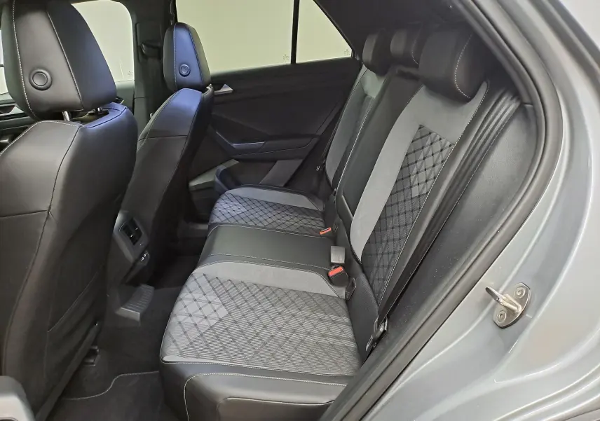 Vue intérieure côté droit des sièges arrière en tissu et cuir noir du Volkswagen T-Roc gris pyrite 2025.