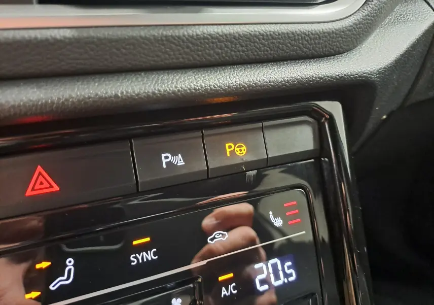 Gros plan sur la console centrale du Volkswagen T-Roc 2025, montrant les commandes de climatisation et sièges chauffants.