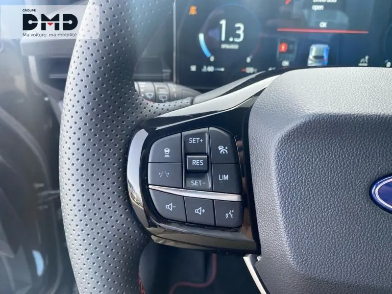 Gros plan sur les commandes multifonctions au volant perforé noir du Ford Puma 2026, affichage numérique en arrière-plan.