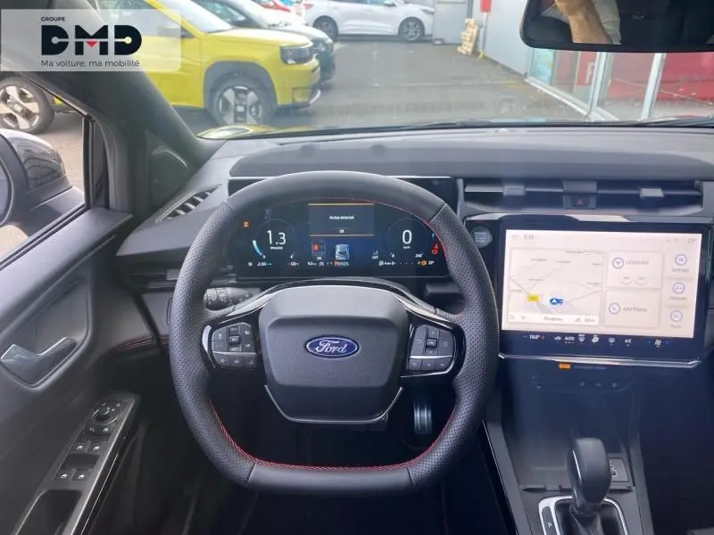 Vue intérieure centrée sur le volant noir avec surpiqûres rouges et tableau de bord numérique du Ford Puma 2026.