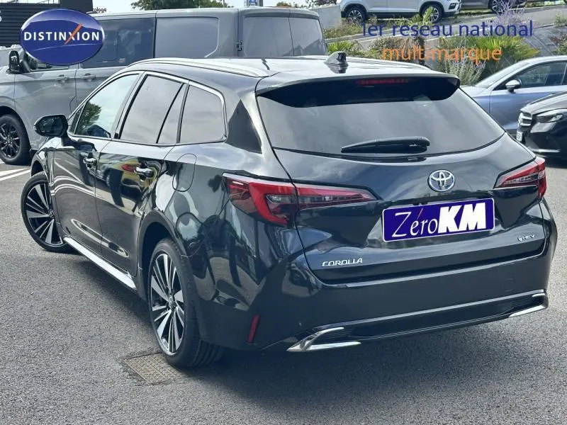 Vue 3/4 arrière droite d'une Toyota Corolla noire hybride 2025 avec jantes alu et feux arrière LED distinctifs.