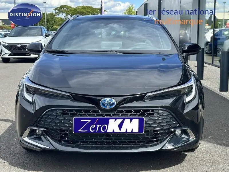 Vue de face d'une Toyota Corolla 1.8 Hybrid noire 2025 avec calandre large et phares LED distinctifs.