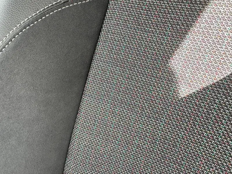 Gros plan sur le tissu noir texturé et la couture blanche du siège avant de la Toyota Corolla 1.8 Hybrid 2025.