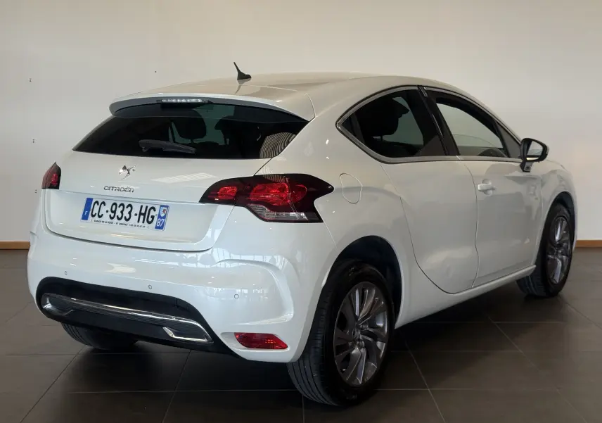 Vue 3/4 arrière droite d'une Citroën DS4 blanche de 2012, avec feux arrière rouges et jantes alliage foncé.