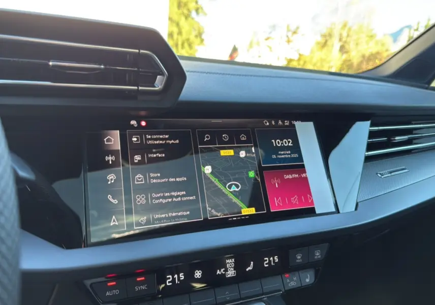 Tableau de bord de l'Audi A3 TFSI 150 Hybrid S-Line 2025 en noir mythic, vue de face sur l'écran tactile central et commandes climatisation.
