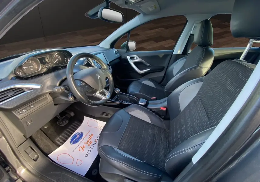 Intérieur de la Peugeot 2008 2019 vu côté conducteur, sièges tissu noir et gris avec volant multifonction.